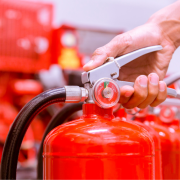 person's hand holding a fire extinguisher