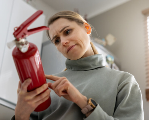 woman check the fire extinguisher expiration date at home